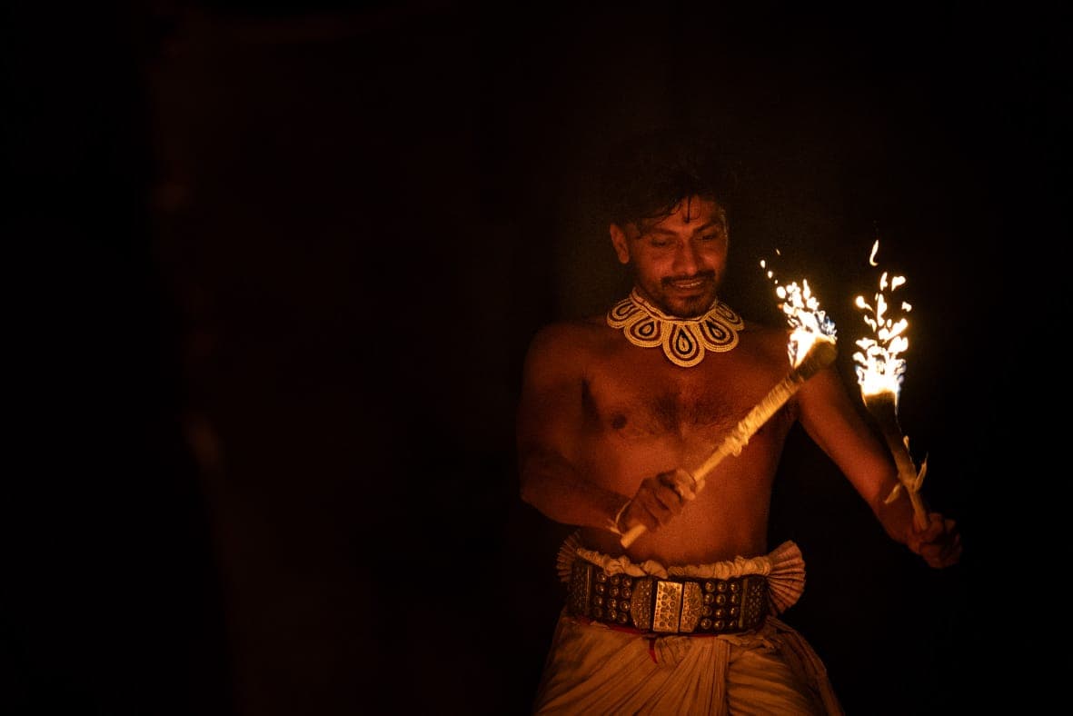 Kandyan dancer performing with twin fire torches