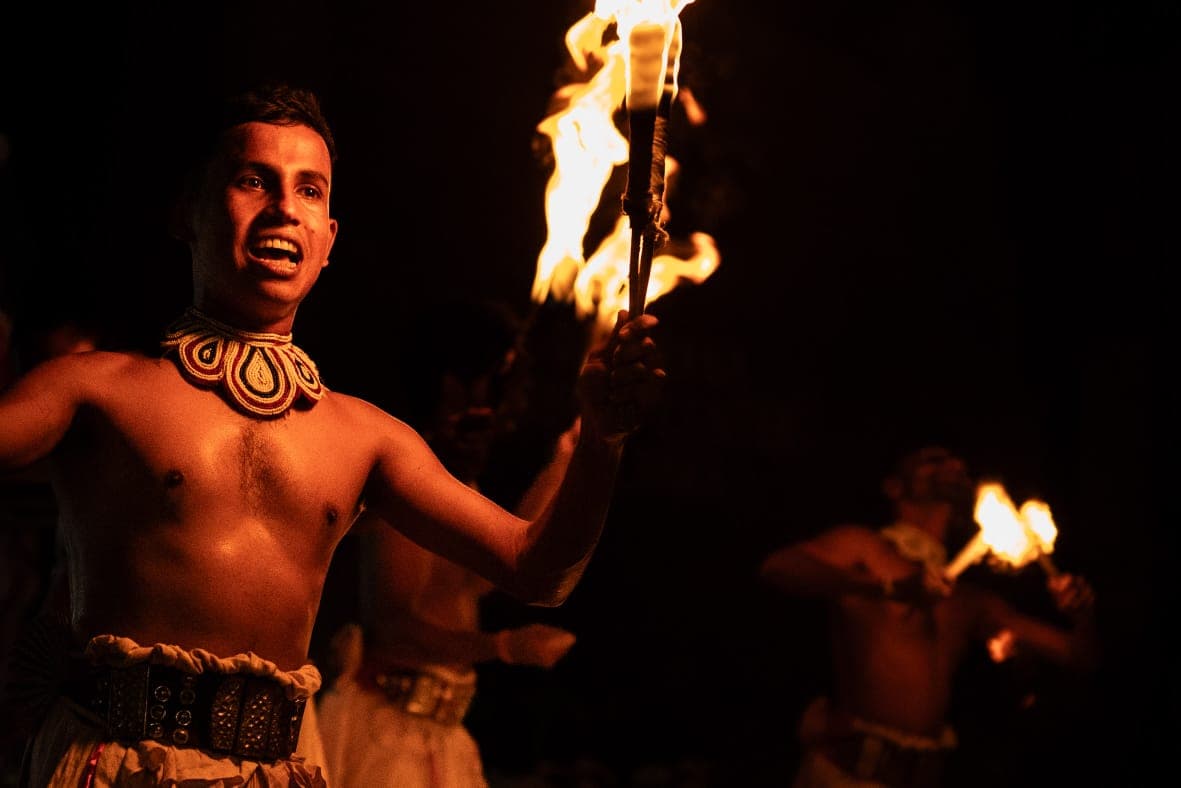Performer holding a burning torch during a traditional Sri Lankan fire ritual
